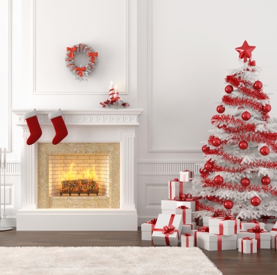 White fireplace with red stockings beside a white Christmas tree with red trimmings and presents