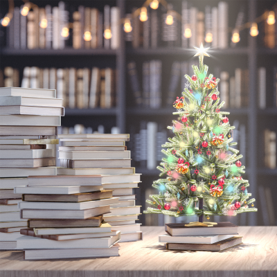 Small Christmas tree on a table with books stacked next to it