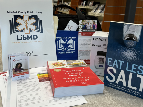 A display of materials from the LibMD kit for high blood pressure. Included are the books Eat Less Salt and The American Heart Association Cookbook; a blood pressure cuff; printed materials; a blood pressure log; and a brochure on exercise.