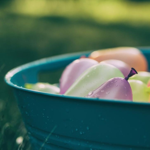 basket of water balloons sitting in the grass