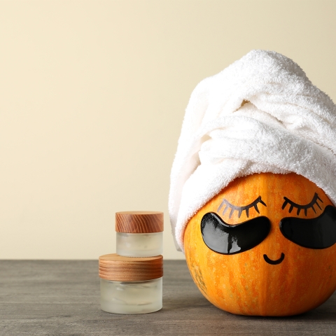 pumpkin with towel wrapped around the top, face, and eye masks