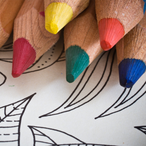 colored pencils sitting atop a coloring page
