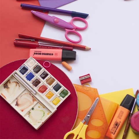 a collection of craft supplies including paint, scissors and colored pencils