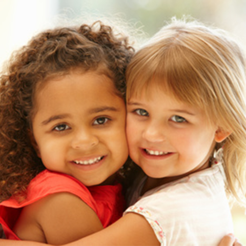 two PreK girls hugging