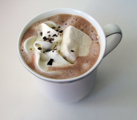 a white cup filled with hot chocolate and marshmallows