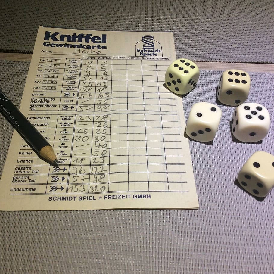 A Yahtzee score sheet, pencil, and dice